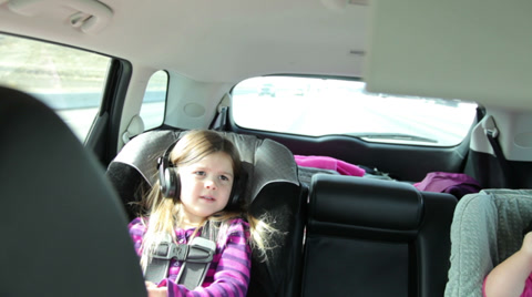 Young Girl Listening To Music During Car Ride