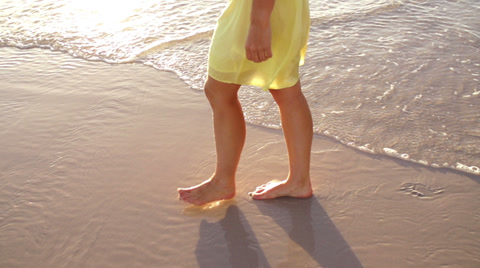 Woman Walking Over Wet Sand On Beach