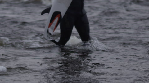 Panning Slow Motion Shot Of Surfer Getting Out Of Water