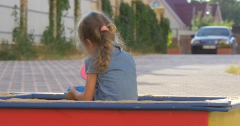 A Little Girl Playing In Sandbox