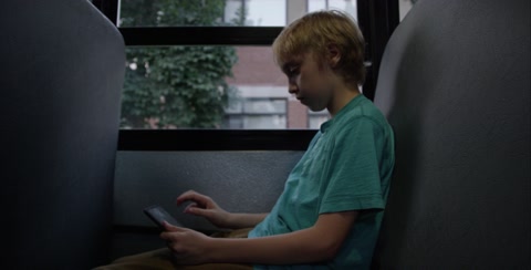 Boy On Ipad On School Bus