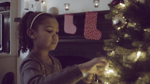 Little Girl Decorates Christmas Tree