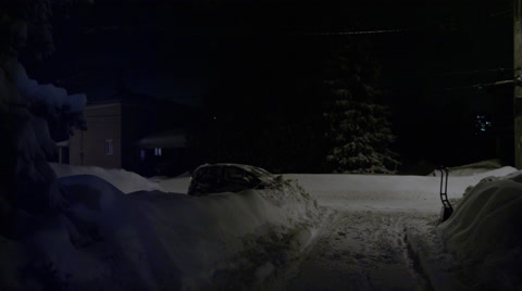 Man Shovelling Driveway At Night After A Blizzard