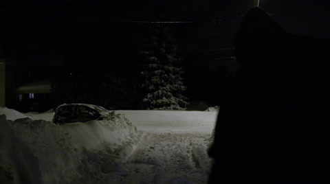 Man Shovelling Driveway At Night After A Blizzard