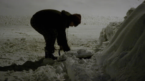 Man Shovelling Driveway At Night After A Blizzard