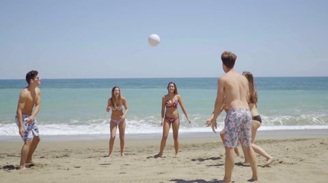 Group Of Young Friends Playing Soccer On A Beach