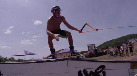 Extreme Sports - Wakeboarder Doing A Board Slide On A Winch Setup Obstacle