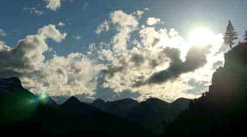 Glacier National Park With Clouds And Lone Tree Silhouette