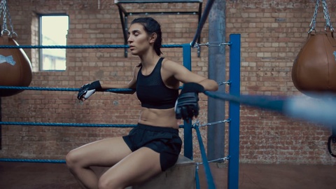 Portrait Of Female Boxer On Ropes In Training Fitness Gym